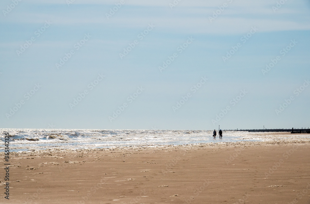 Silhouette of couple walking on beach.