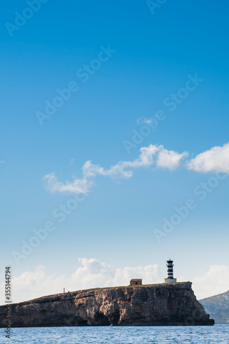 Maritime landscape on a sunny day of the "Na Foradada" Lighthouse on an islet in the Cabrera Archipelago National Park, Balearic Islands, Spain. Vertical composition