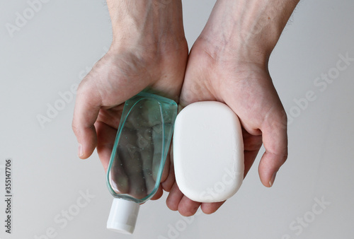 Man holding antibacterial gel hand sanitizer and antibacterial soap in his hands, coronavirus protection concept, medical background, clean hands backdrop