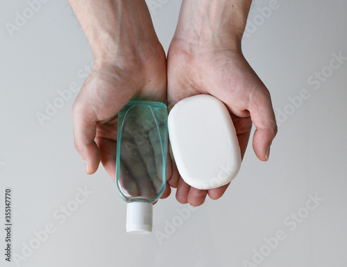 Man holding antibacterial gel hand sanitizer and antibacterial soap in his hands, coronavirus protection concept, medical background, clean hands backdrop