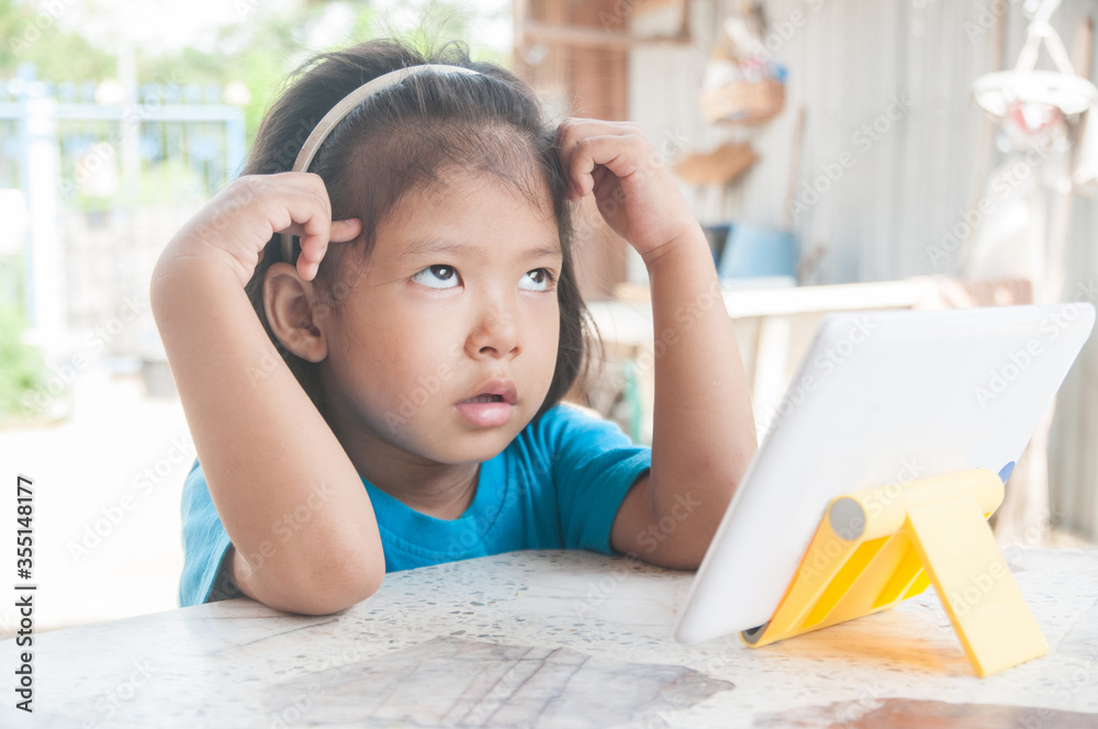 Confuse Asian Girl learning online course or playing game online at home. Confuse Asian Girl learning online course or playing game online at home.
