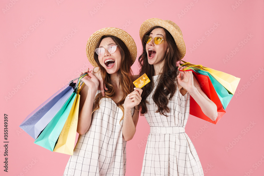 © Drobot Dean - Image of excited women holding sopping bags and credit card