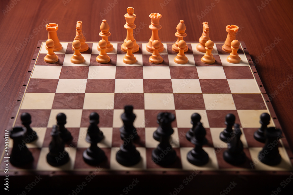 game of chess on a brown wooden table game of chess on a brown wooden table