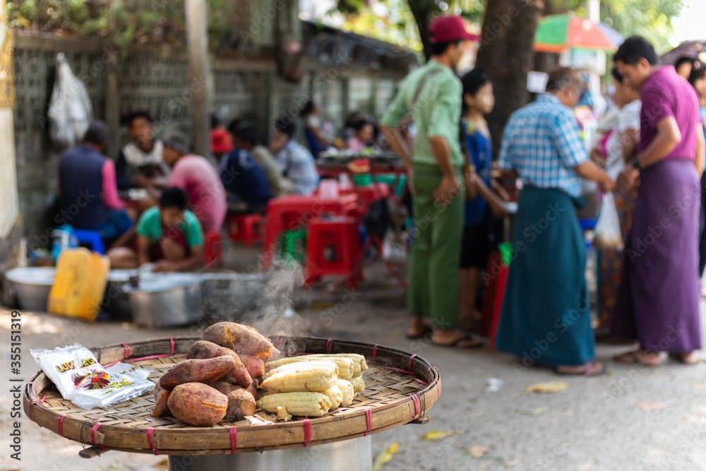 Steam corn and sweet potato cooking slowly at a stall in a street market. Yangon - Rangoon, Myanmar - Burma, Southeast Asia