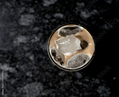 iced coffee in glass bottom with black background