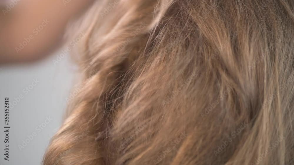 Creating a karsive hairstyle from a young beautiful blonde.