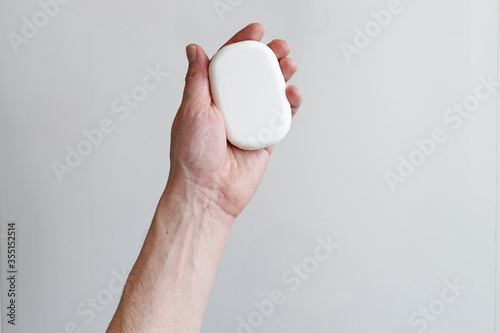 Man's hand holding a soap, man hands holding white antibacterial soap, self hygiene concept, covid-19 prevention