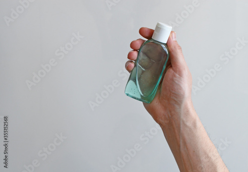 Man holding hand sanitizer bottle, man's hand with disinfectant bottle isolated on white background, coronavirus prevention concept backdrop background
