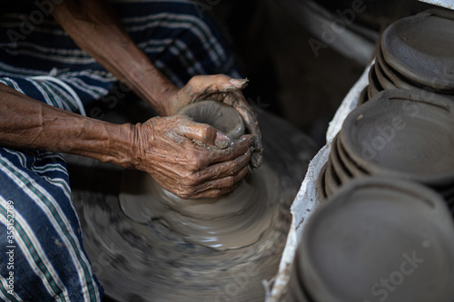 male potter is making a vase from clay, selective focus.