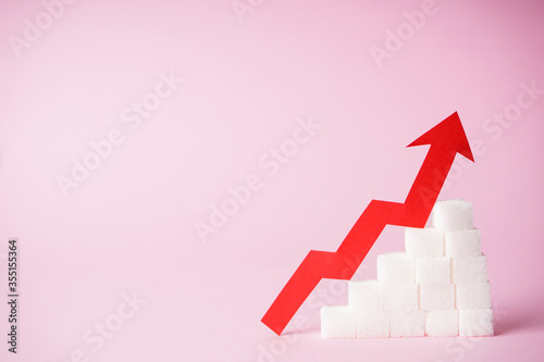 Εκτύπωση καμβά Increase in blood sugar levels, the graph of growth of the sugar cubes and arrow on top on a pink background with space for text