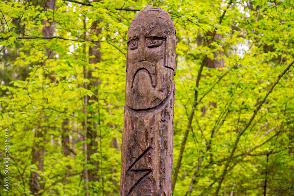 The image of the Slavic deity Veles carved from a tree trunk on a neo-Pagan temple in the forest. Kaluzhskiy region, Russia. Veles - the god of cattle breeding, wealth and wisdom The image of the Slavic deity Veles carved from a tree trunk on a neo-Pagan temple in the forest. Kaluzhskiy region, Russia. Veles - the god of cattle breeding, wealth and wisdom