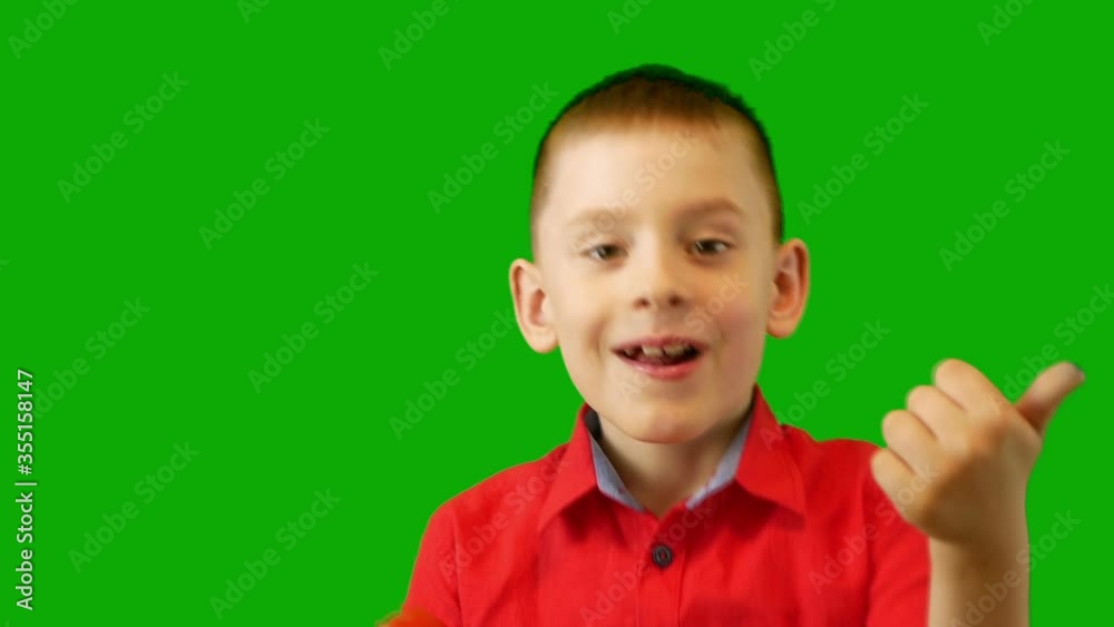 Close-up the child eats juicy appetizing tomato with pleasure and shows his delight. Green screen Close-up the child eats juicy appetizing tomato with pleasure and shows his delight. Green screen