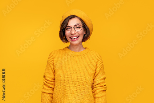 Cheerful young woman in stylish hat and sweater