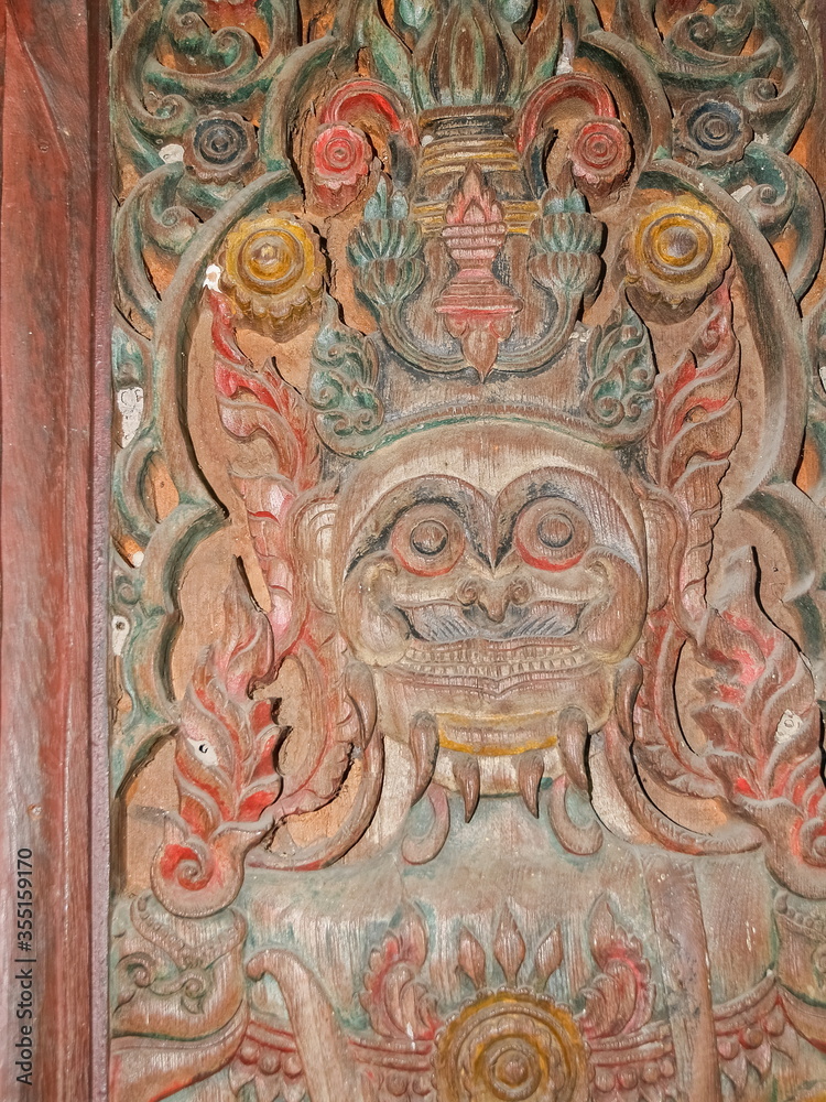 view of Giant goddess guarding wood carving on the door of buddhist temple, Wat Chet Yot or officially called Wat Photharam Maha Wihan in Chiang Mai City, northern of Thailand. view of Giant goddess guarding wood carving on the door of buddhist temple, Wat Chet Yot or officially called Wat Photharam Maha Wihan in Chiang Mai City, northern of Thailand.