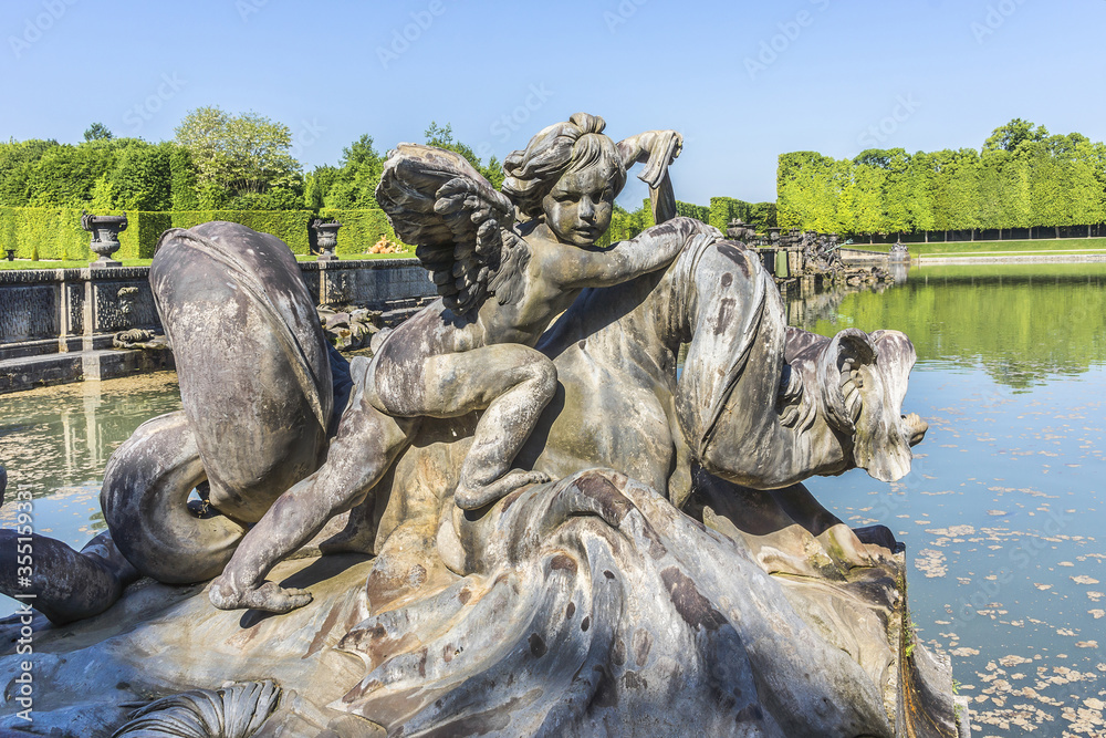 Neptune Fountain (1770) in gardens of famous Versailles palace. Palace of Versailles was a royal chateau. It added to UNESCO list of World Heritage Sites. Versailles, Paris, France.