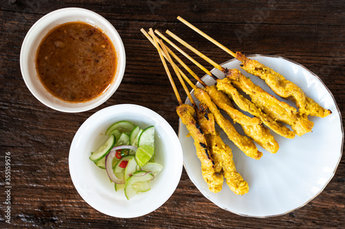 The pork satay in a dish placed on a wooden table