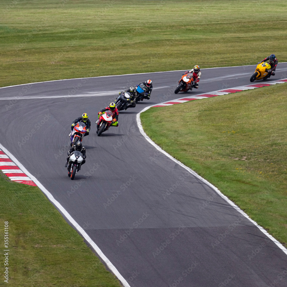 Multiple racing bikes cornering on a track