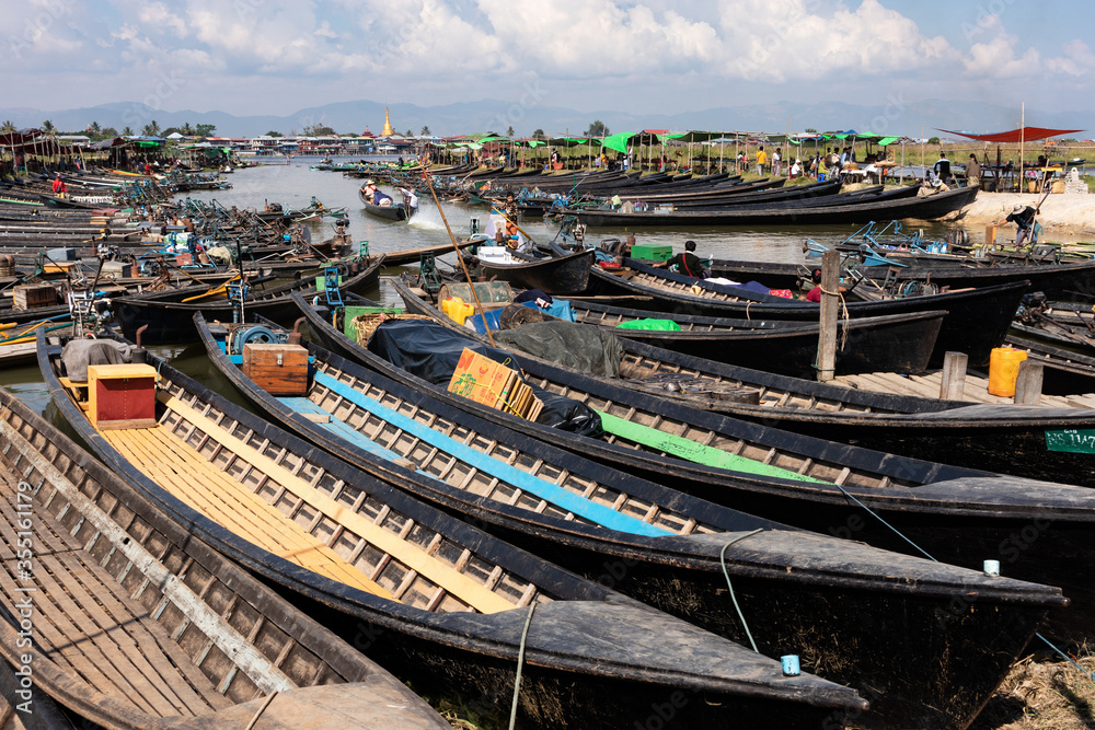 Traditional burmese boats made of teak wood and painted in black lacquer. Floating market. Inle lake, Myanmar - Burma, Southeast Asia