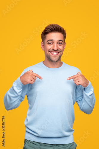 Cheerful man pointing at chest