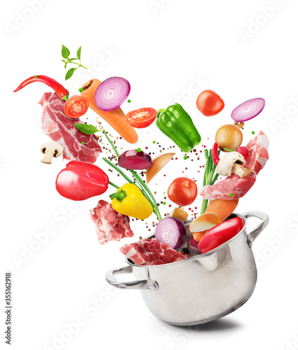 Cooking concept. Vegetables and bacon are falling on a pan isolated on white background. Healthy food.