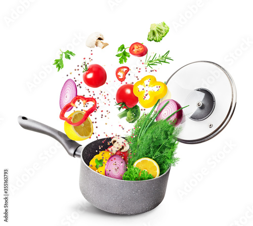 Cooking concept. Vegetables and bacon are falling on a pan isolated on white background. Healthy food.