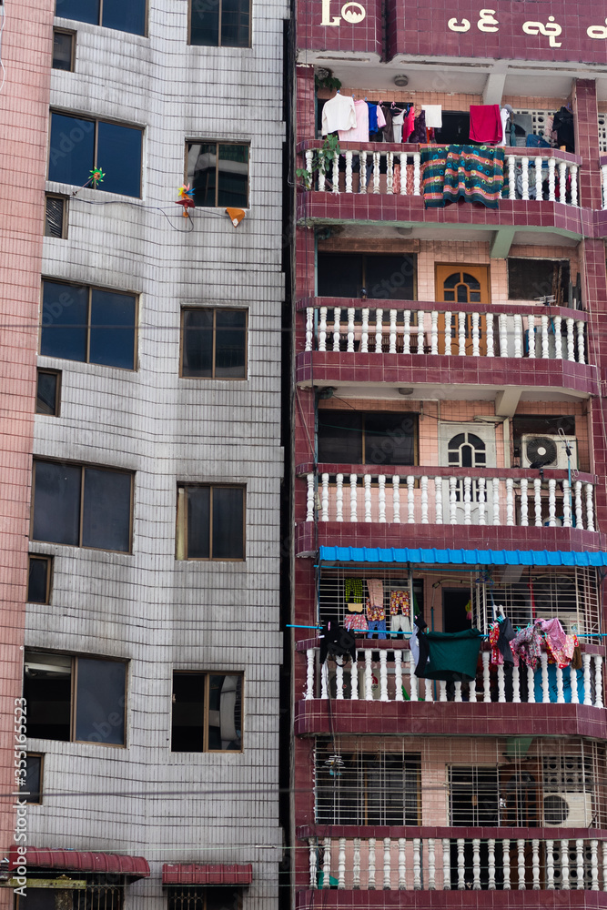 Building with apartments in the city of Yangon. Windows, balconies, air conditioning equipment. Vertical orientation. Yangon - Rangoon, Myanmar, Burma, Southeast Asia