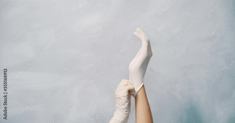 Close up of female hands wearing protective gloves on a gray background. Copy space. Close up of female hands wearing protective gloves on a gray background. Copy space.