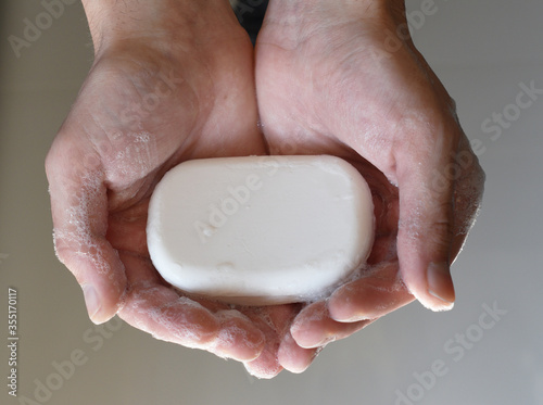 Man's hand holding a soap, man hands holding white antibacterial soap, self hygiene concept, covid-19 prevention