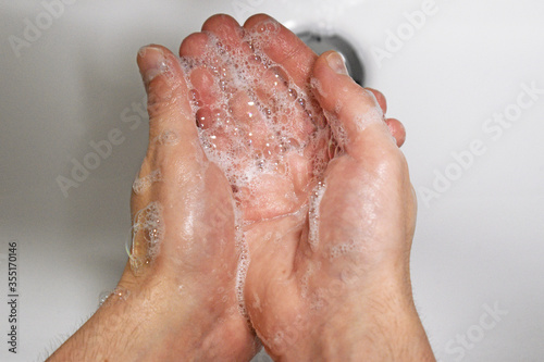 Man washing his hands with soap, wash hands concept soap foam closeup, virus prevention
