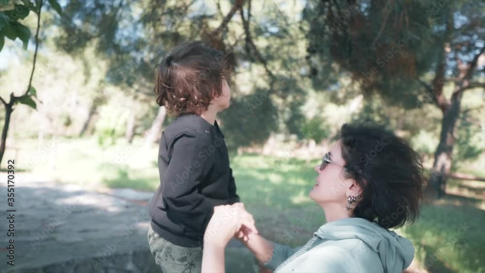 Kid is playing wooden game center in nature and his mother is playing with him. Mother and children concept. Happy, hope family. Kid is playing wooden game center in nature and his mother is playing with him. Mother and children concept. Happy, hope family.