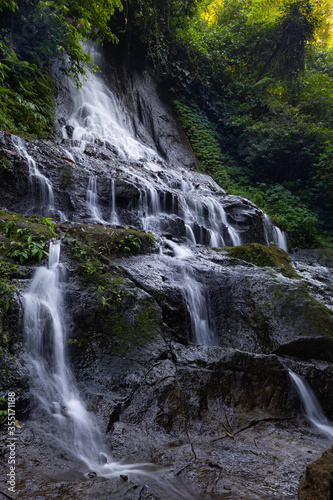 Waterfall landscape. Beautiful hidden Goa Giri Campuhan waterfall in tropical rainforest in Bali. Nature background. Slow shutter speed, motion photography.