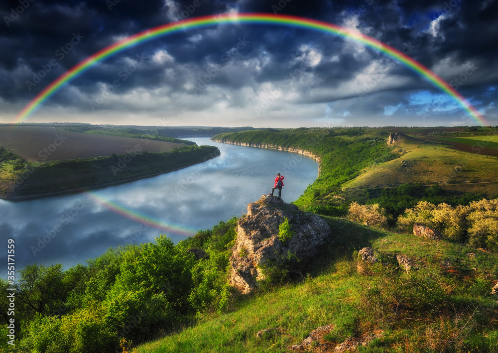 Obraz premium Woman Looking At Rainbow. rainbow over river canyon