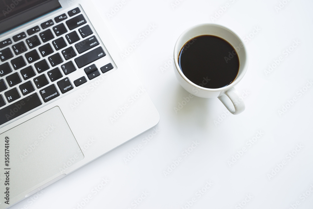 White office desk table with laptop computer, cup of black hot coffee White office desk table with laptop computer, cup of black hot coffee