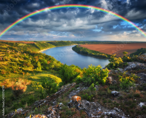 colorful rainbow over river canyon