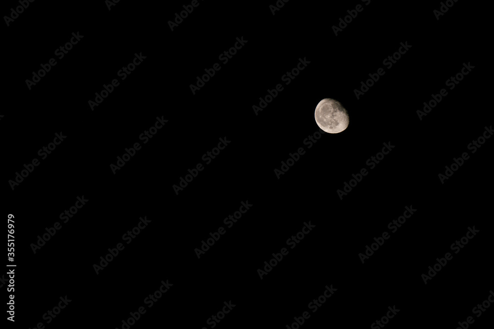 A beautiful textured Waning gibbous moon is on the dark sky at night. Natural sky background A beautiful textured Waning gibbous moon is on the dark sky at night. Natural sky background