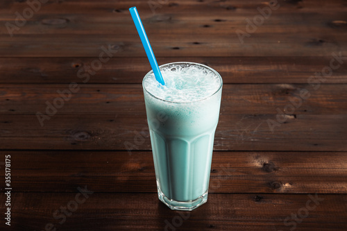 Blue milkshake on a dark wooden background