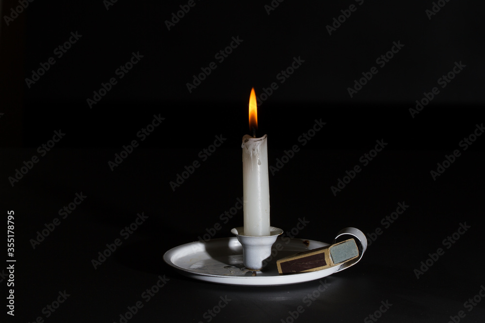 Lit candle in holder with matches Lit candle in holder with matches
