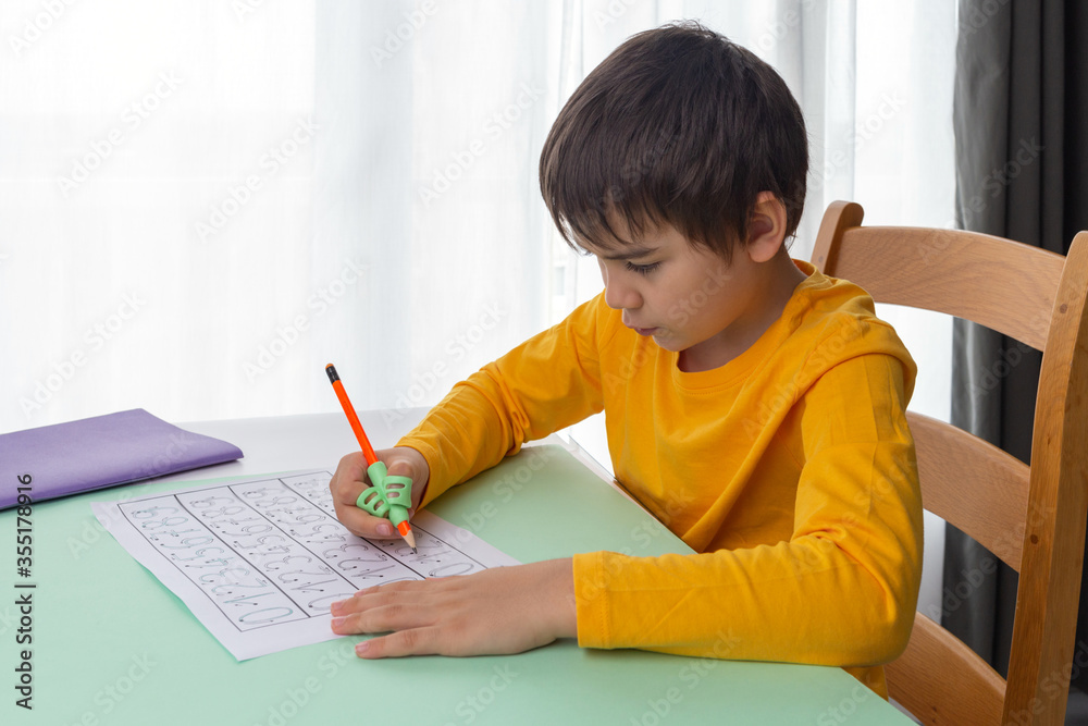 child do homework, boy use ergonomic training pencil holder, correcting pencil grip, teaching children how to hold a pen, handwriting finger exercises child do homework, boy use ergonomic training pencil holder, correcting pencil grip, teaching children how to hold a pen, handwriting finger exercises