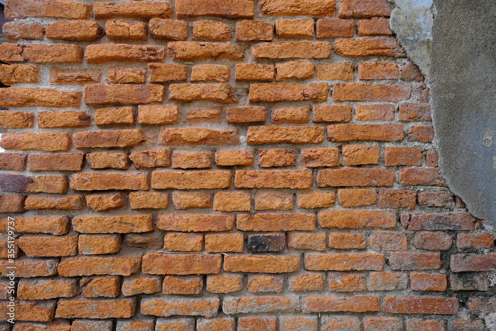 Fototapeta premium Structure of decaying vintage clay bricks wall and cement, weathered textured pattern background with copy space.