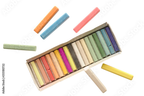 Crayons pastels in different colors. Lying in a box in their places. On a white isolated background.
