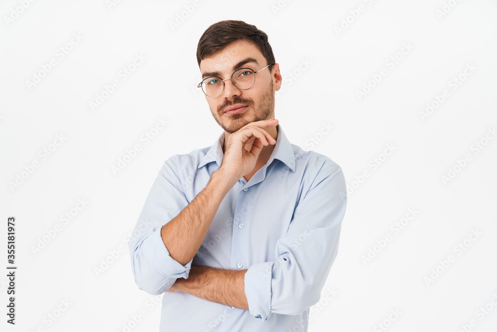 Photo of thinking young man in eyeglasses posing and looking at camera Photo of thinking young man in eyeglasses posing and looking at camera
