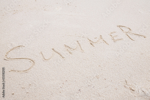 Concept: SUMMER word on white clean sand.