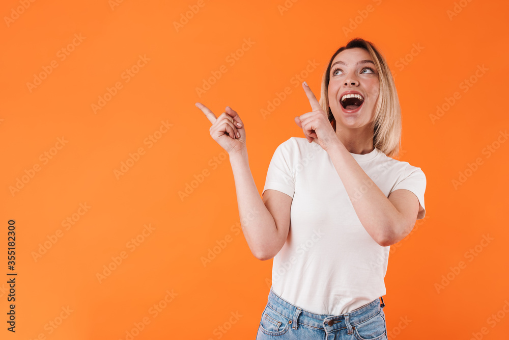 Image of excited caucasian woman smiling and pointing fingers upward Image of excited caucasian woman smiling and pointing fingers upward