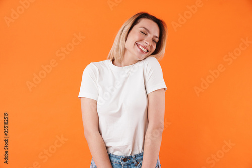 Image of joyful attractive woman laughing with eyes closed