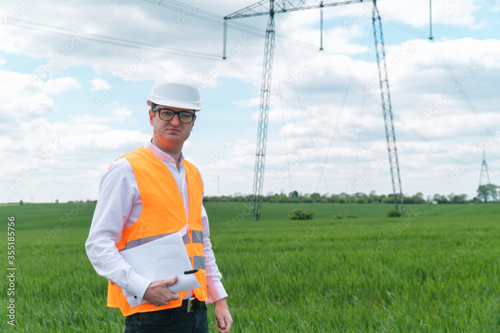 Engineer working near transmission lines. Transmission towers
