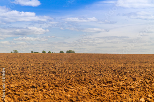 Fresh plowed field in Russia. Arable land in spring or autumn. The vast, endless field with the soil.