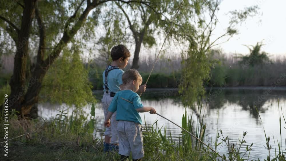 outdoor recreation, curious cheerful male children play with reeds in river near river on background of green trees while relaxing in countryside outdoor recreation, curious cheerful male children play with reeds in river near river on background of green trees while relaxing in countryside