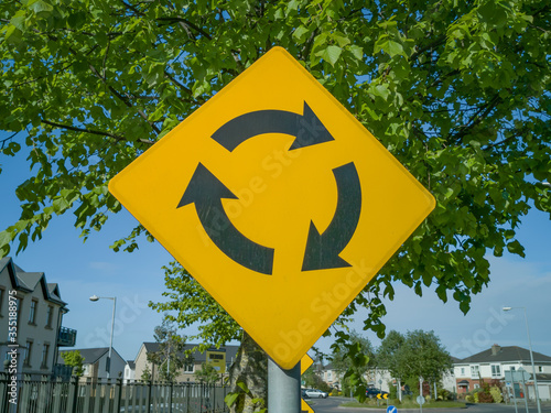 roudabout crossing sign on blue sky photo