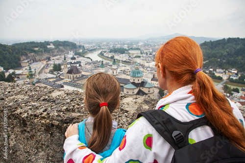 Mother and son admire a city with an observation deck of Hohensalzburg. Austria, Salzburg. Family sightseeing.
