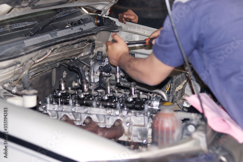 The mechanic is checking the engine.